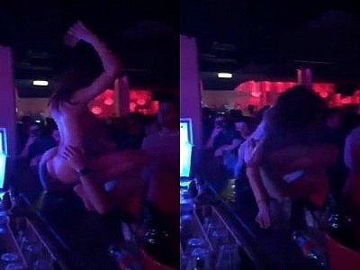 Une stripteaseuse se fait lécher par un client et tombe du bar