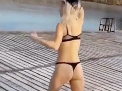 Une blonde saute dans un lac