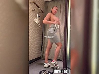 Une blonde super bonne à demie nue dans une cabine d'essayage