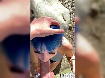 Une sirène aux cheveux bleus suce un homme au bord d'un lac